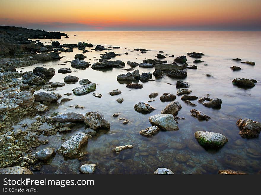 Sea and rock at the sunset. Nature composition.