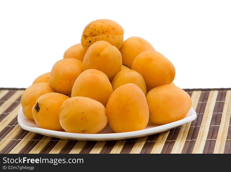 Fresh and ripe apricot on a white plate. Fresh and ripe apricot on a white plate