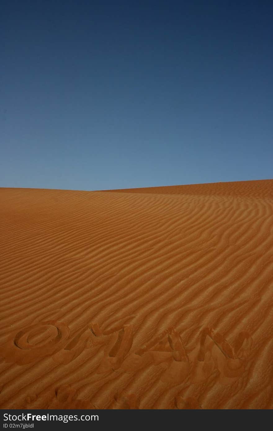 The word OMAN written in the desert sand