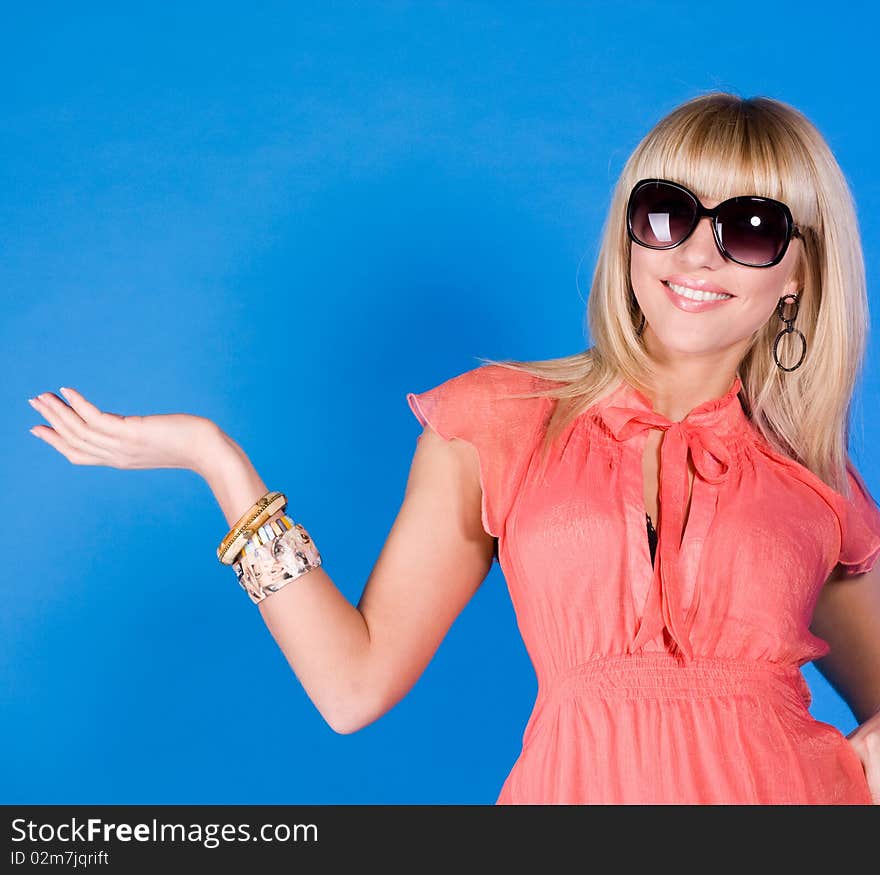 Smiling girl with arm raised on a blue background. Smiling girl with arm raised on a blue background