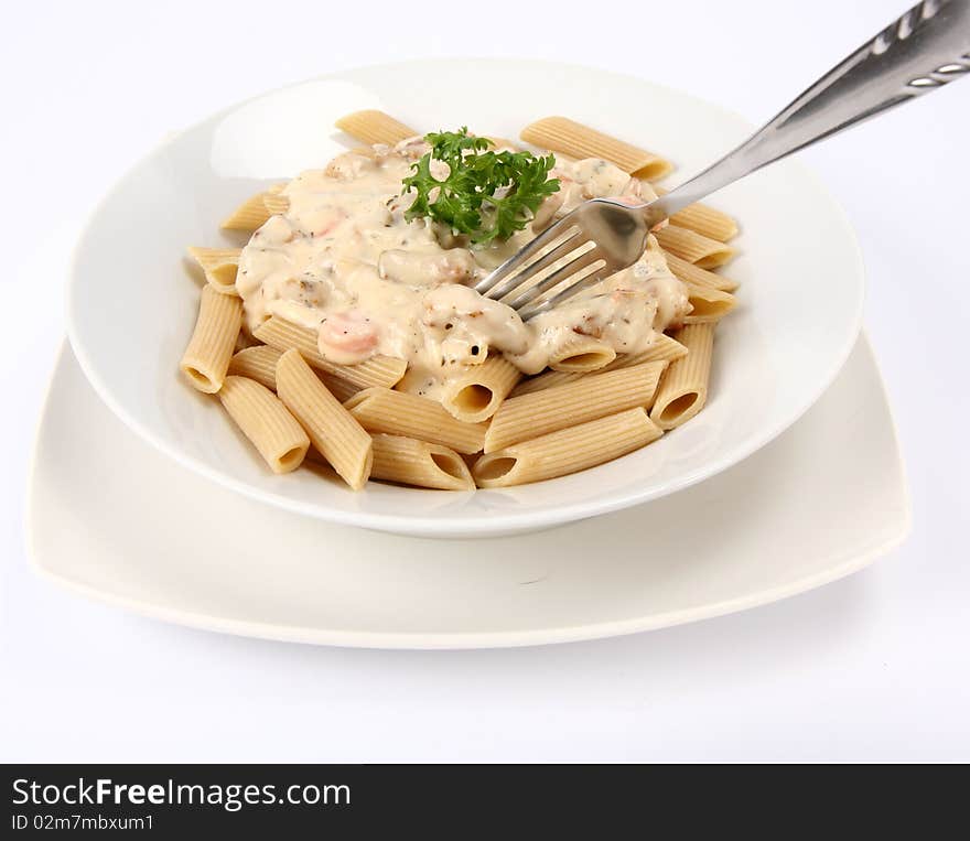 Penne with white sauce on a plate decorated with parsley and a fork