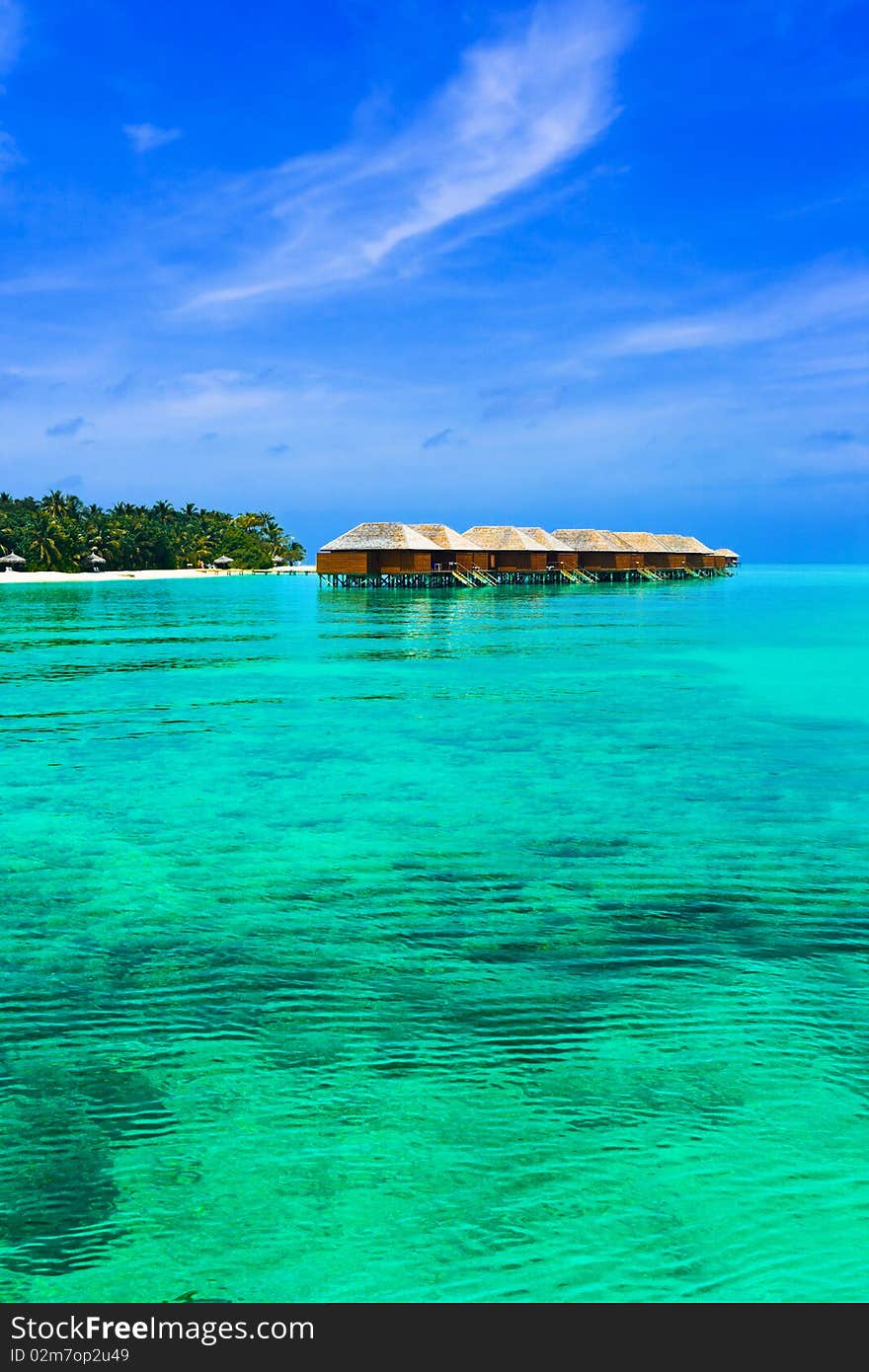 Water bungalows on a tropical island - travel background