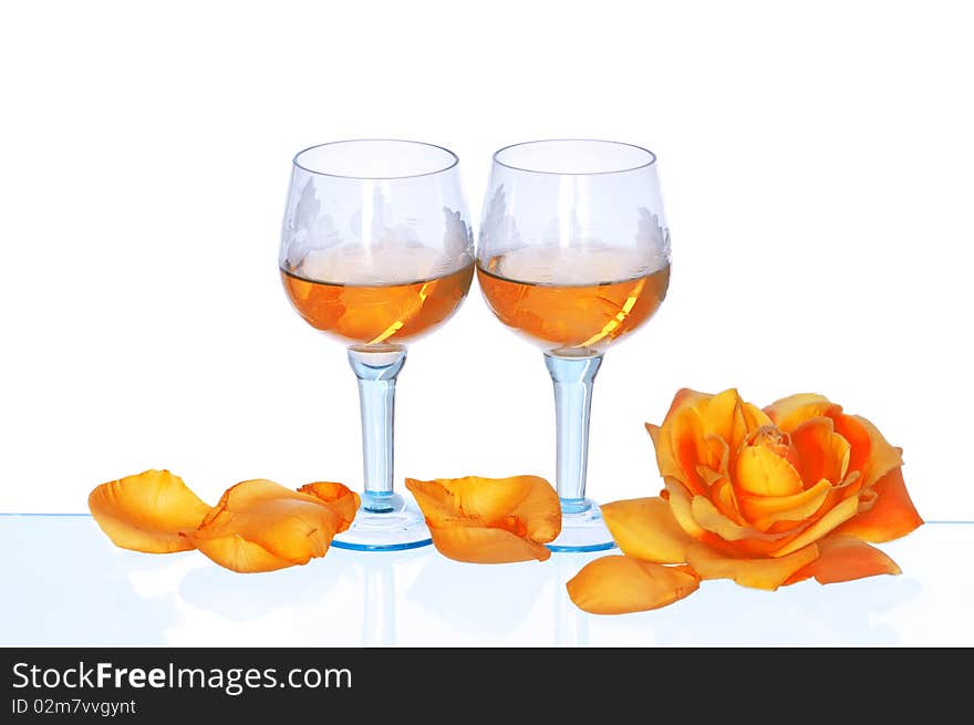 Two tumblers with white wine and yellow rose on the party. Two tumblers with white wine and yellow rose on the party