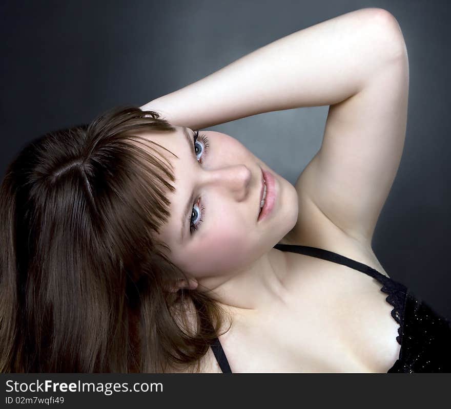 Beautiful brunette girl posing in studio on dark background