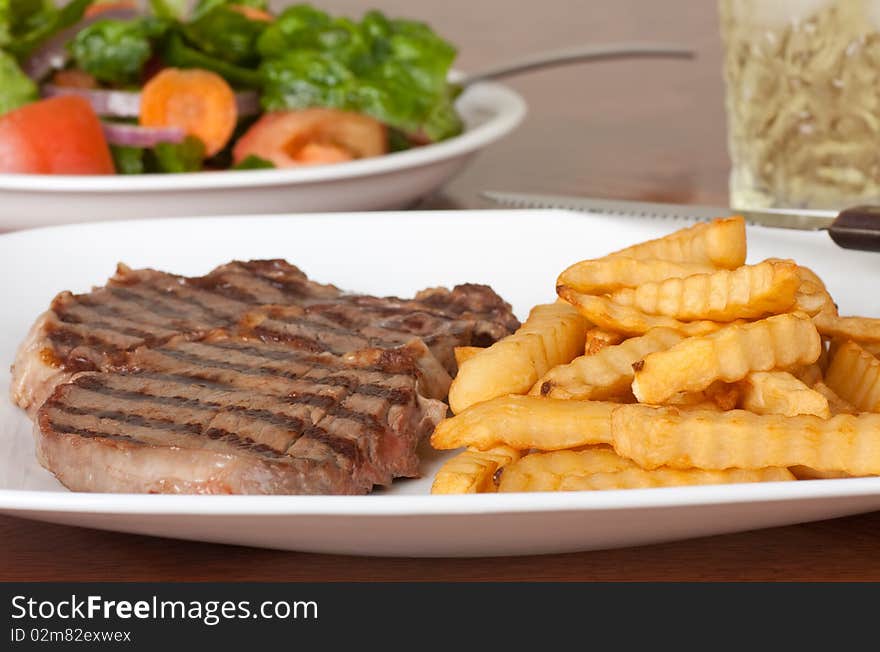 Rib eye steak meal with french fries, salad and drink. Rib eye steak meal with french fries, salad and drink