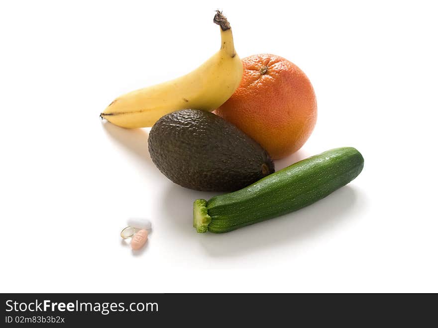 A variety of fresh fruits and vegetables with some vitamin tablets. A variety of fresh fruits and vegetables with some vitamin tablets