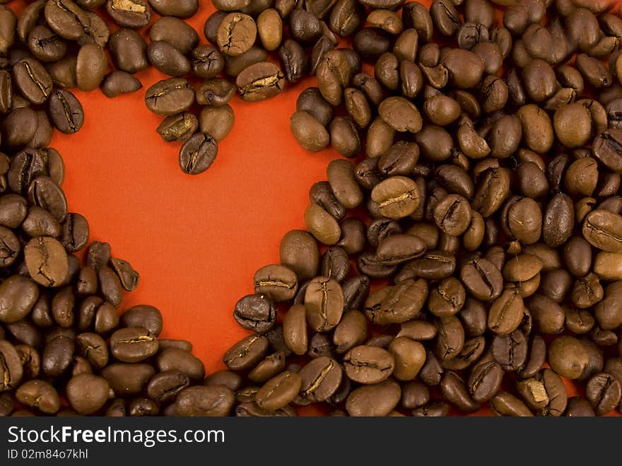 Creative photo of coffee beans making up form of heart of red color