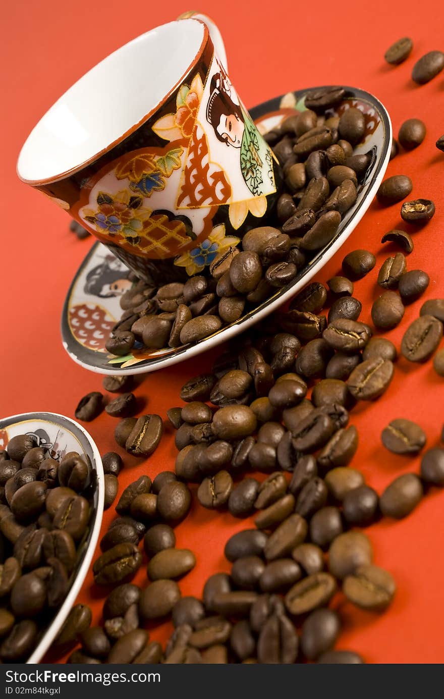 Coffee beans and cup on red background