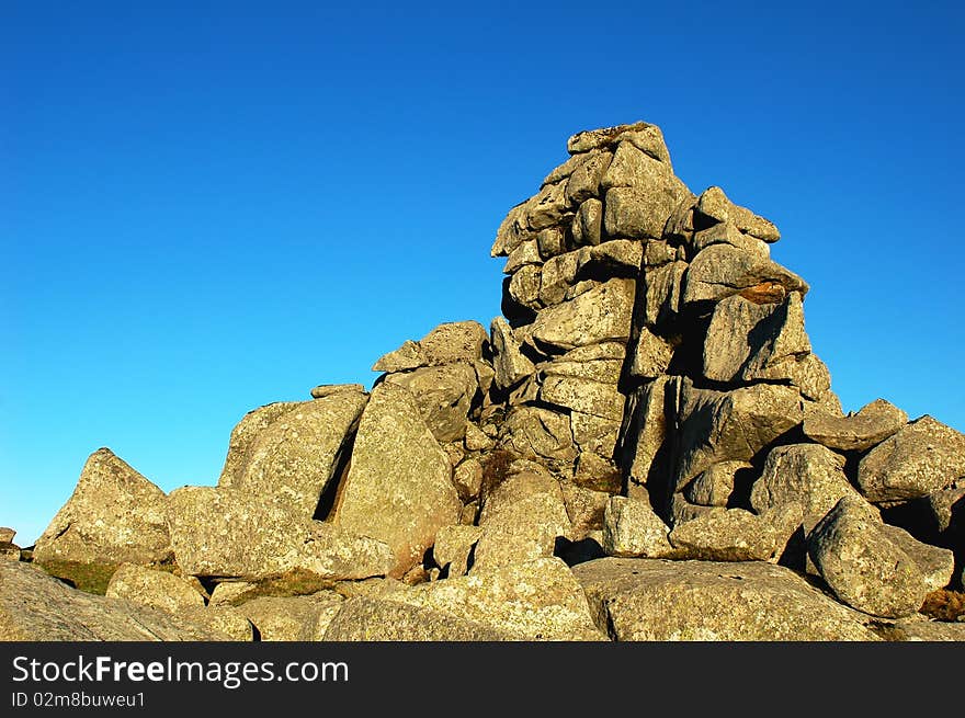 Scenery of huge rocks at the top of mountains with blue skies as backgrounds