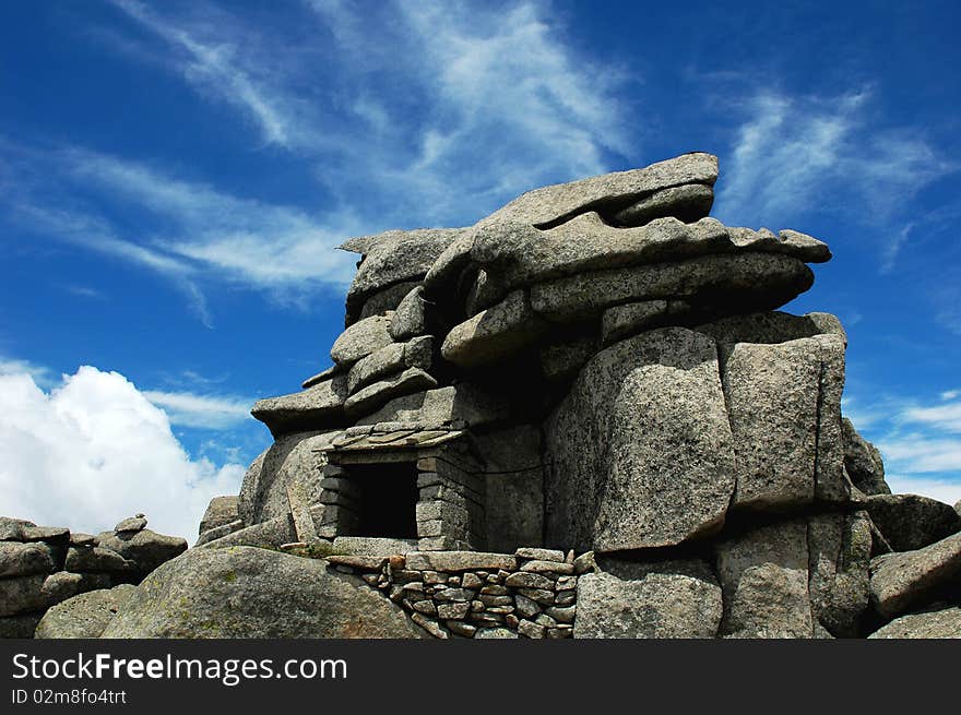 Scenery of huge rocks at the top of mountains with blue skies and white clouds as backgrounds