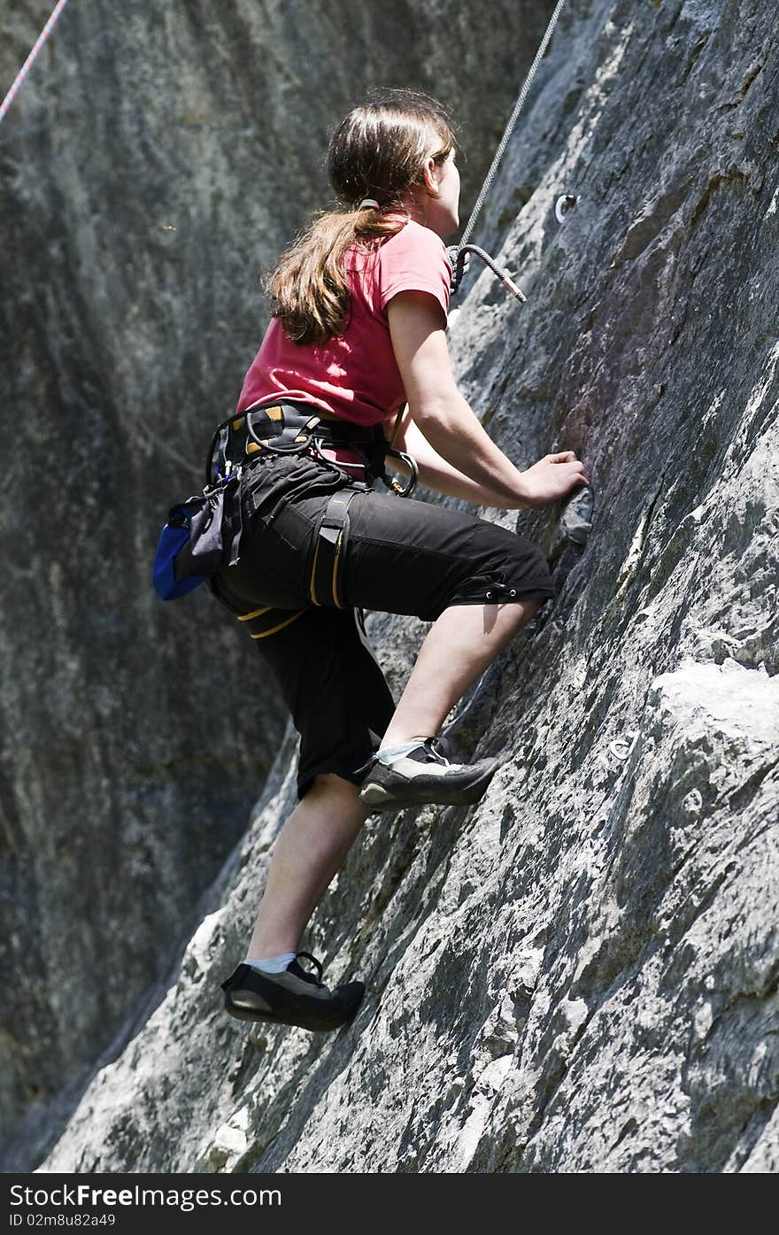 Young sportive girl in the rock face