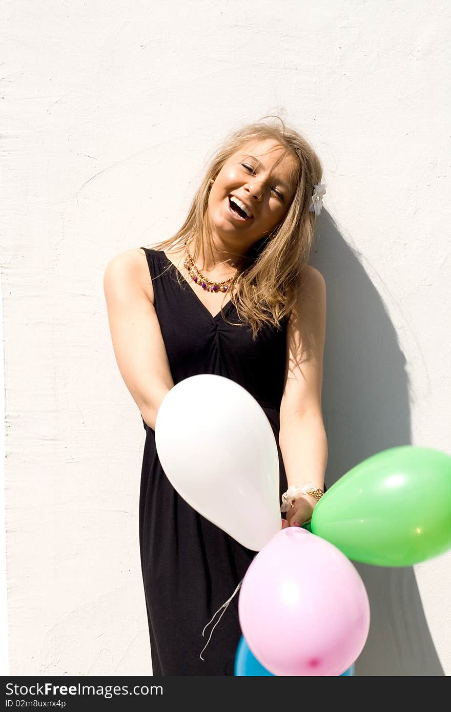 Joyful girl with balloons laughing outdoor