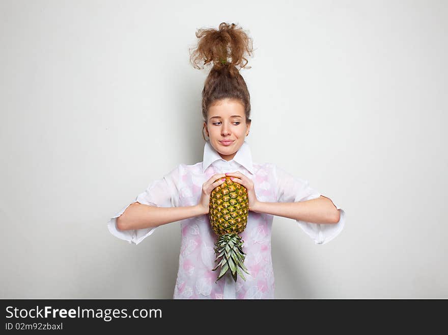 Young pretty girl with a pineapple in her hands