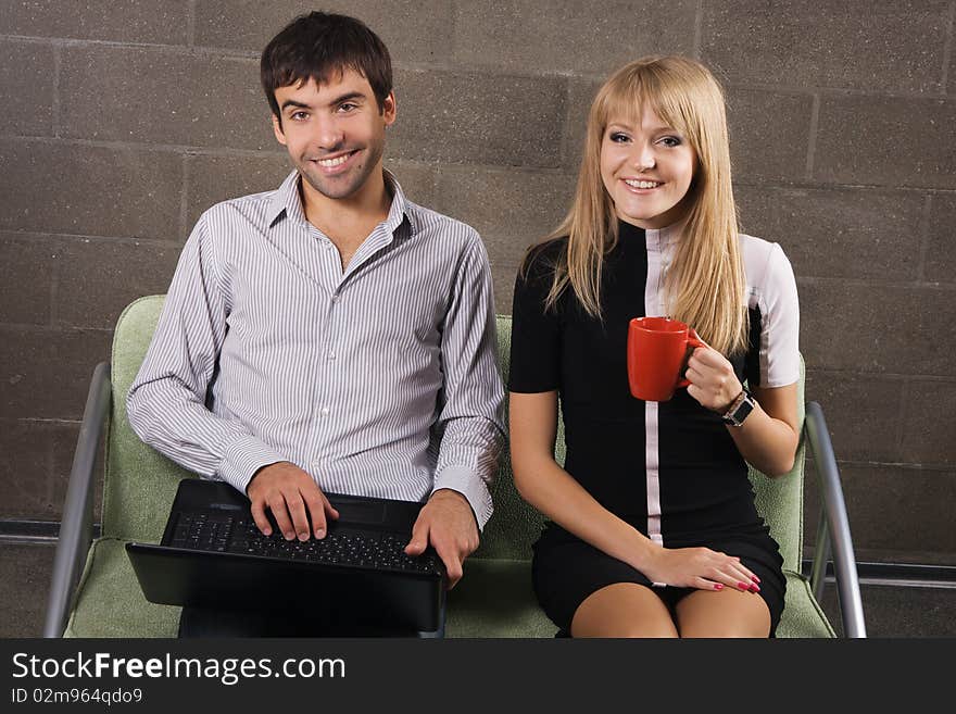 Young man and woman sitting with a laptop indoors