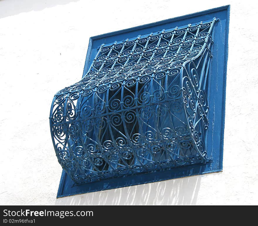 Typical window closed with wrought iron painted in blue in the village of Sidi Bou Said in Tunisia