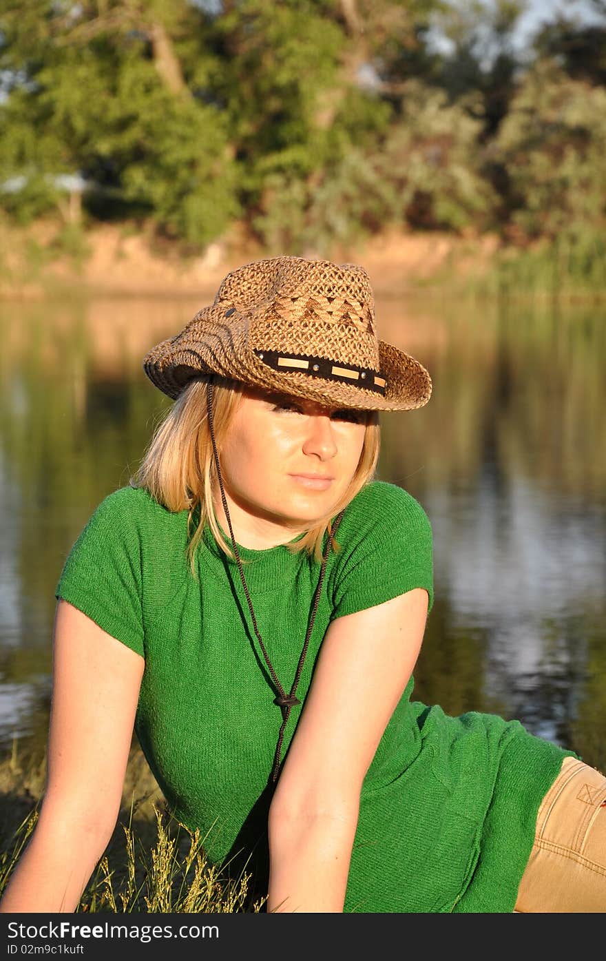 Young nice woman siting near a river. Young nice woman siting near a river