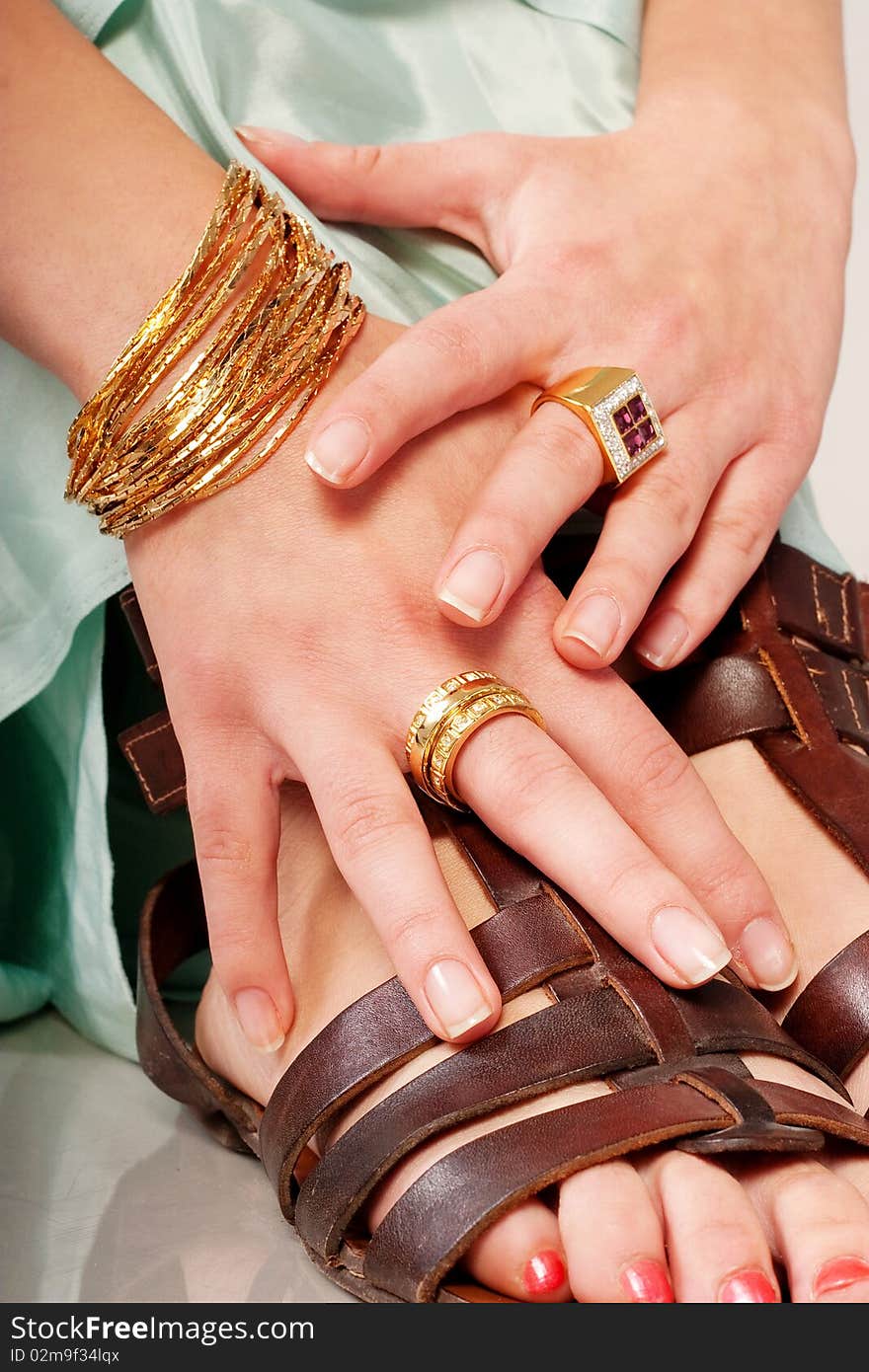 Hand with jewellery holds on feet. Hand with jewellery holds on feet