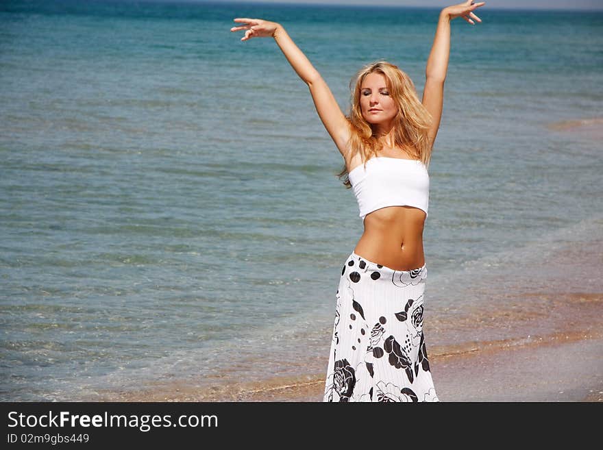 Young beautiful woman posing on sea background. Young beautiful woman posing on sea background