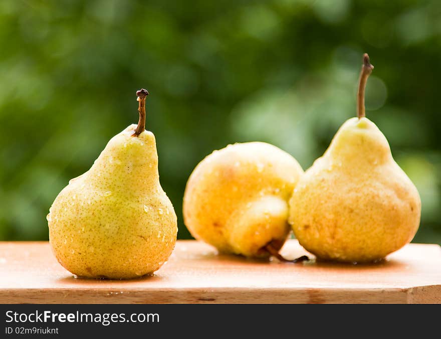 Fresh pears against green background