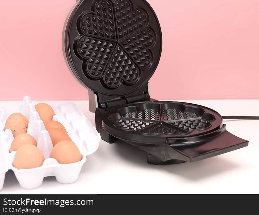 A waffle iron on a kitchen bench