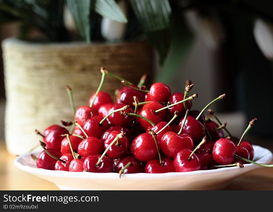 A group of cherries in a plate. A group of cherries in a plate.