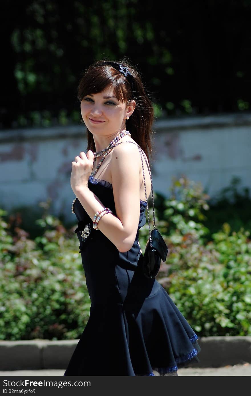 The young woman poses in the street in the summer