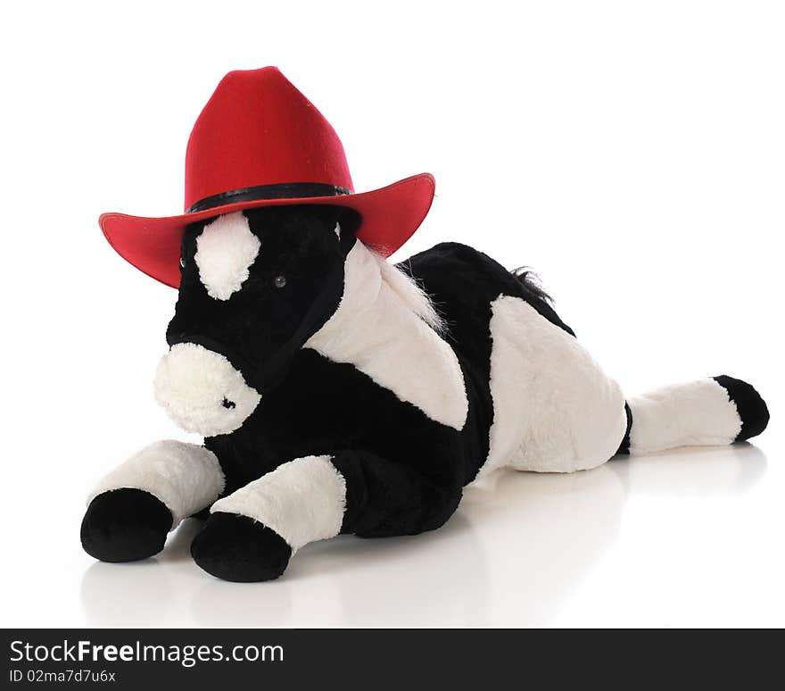 A toy horse wearing a child's bright red cowboy hat. Isolated on white. A toy horse wearing a child's bright red cowboy hat. Isolated on white.