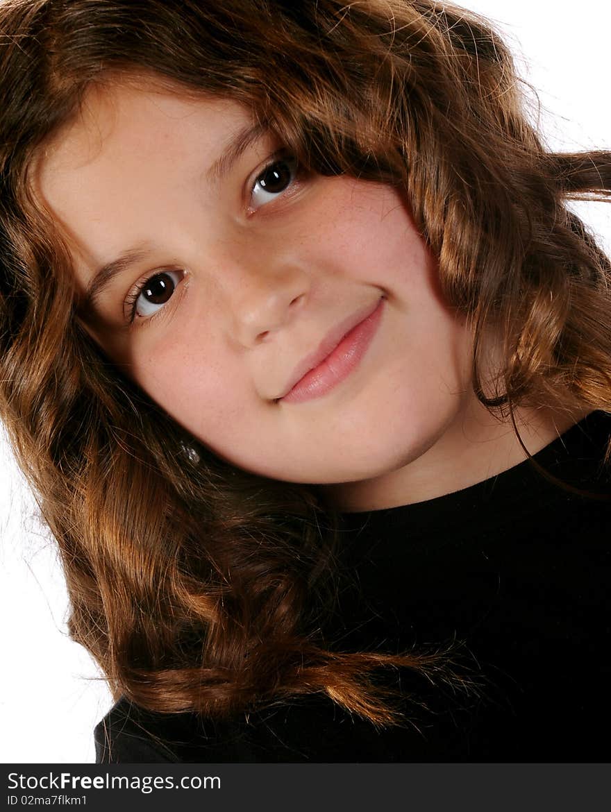 Closeup portrait of a happy, young preteen in ringletts.