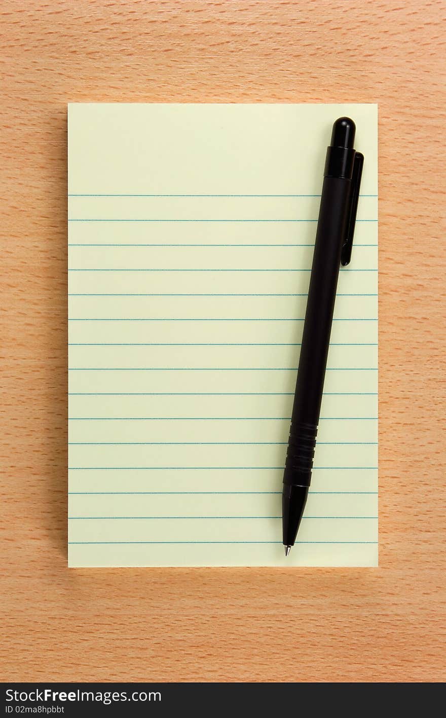 Yellow notepad with the black pen on the wooden table. Yellow notepad with the black pen on the wooden table