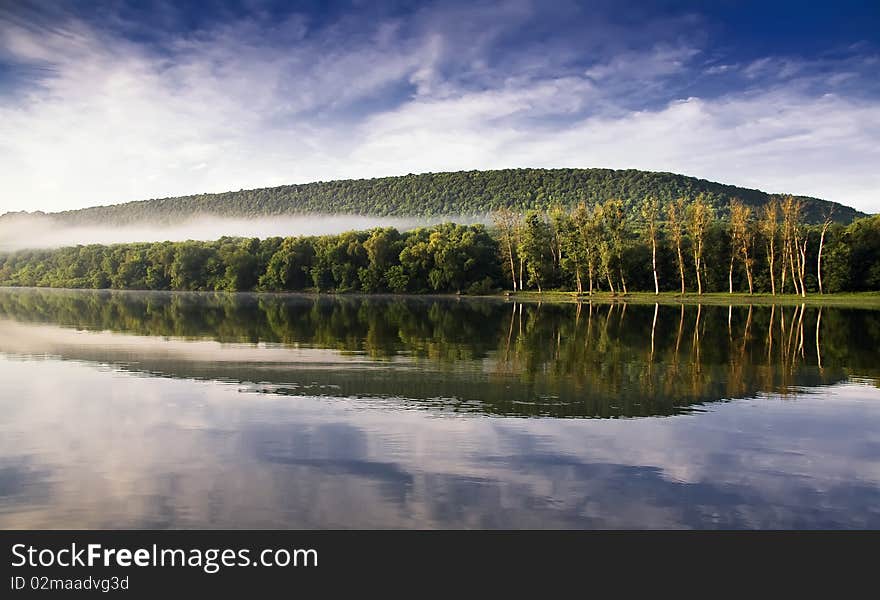 In a river landscape with nature morning with fog