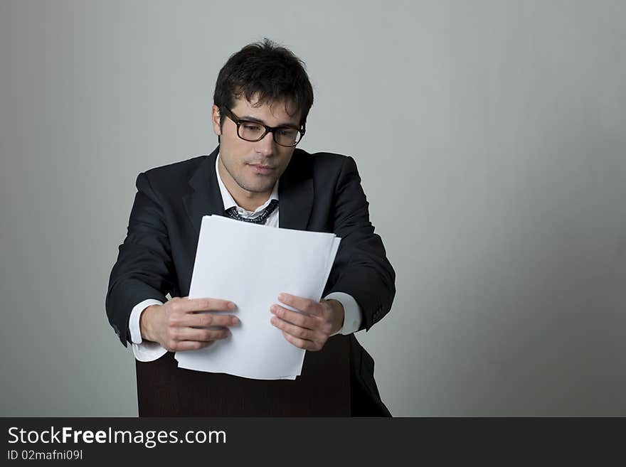 Businessman reading document, isolated on grey