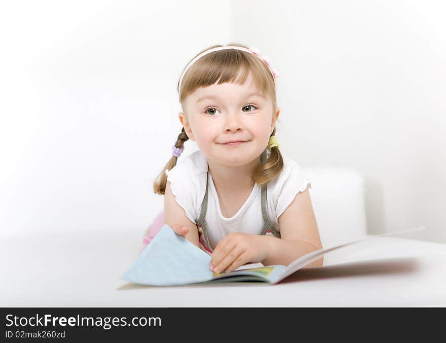 Sweet happy little girl reading book