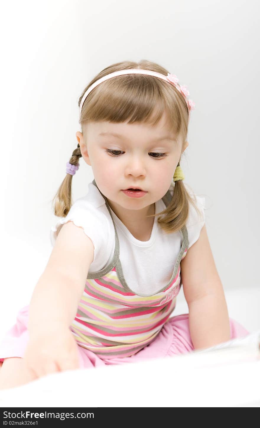 Sweet happy little girl reading book