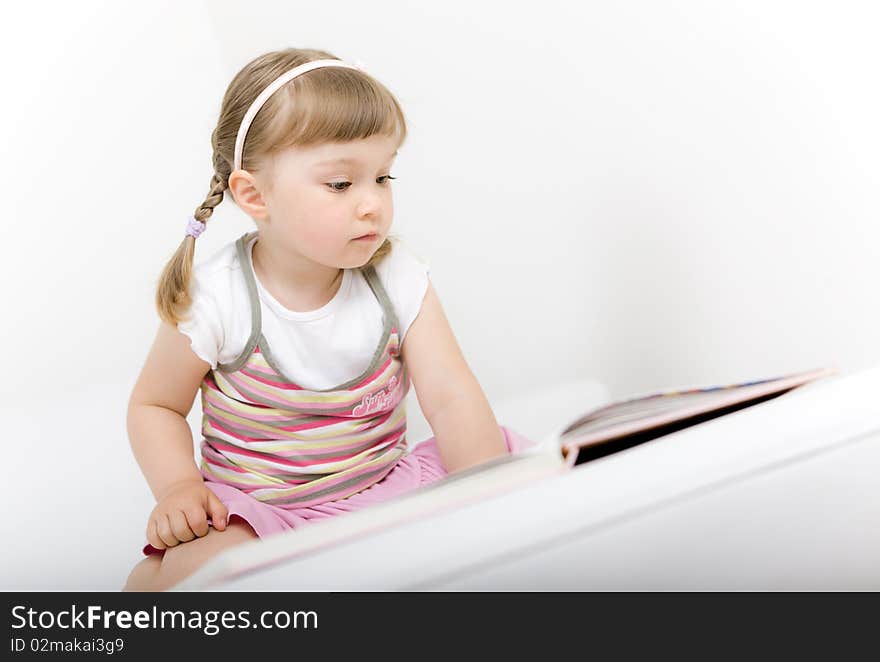 Sweet happy little girl reading book