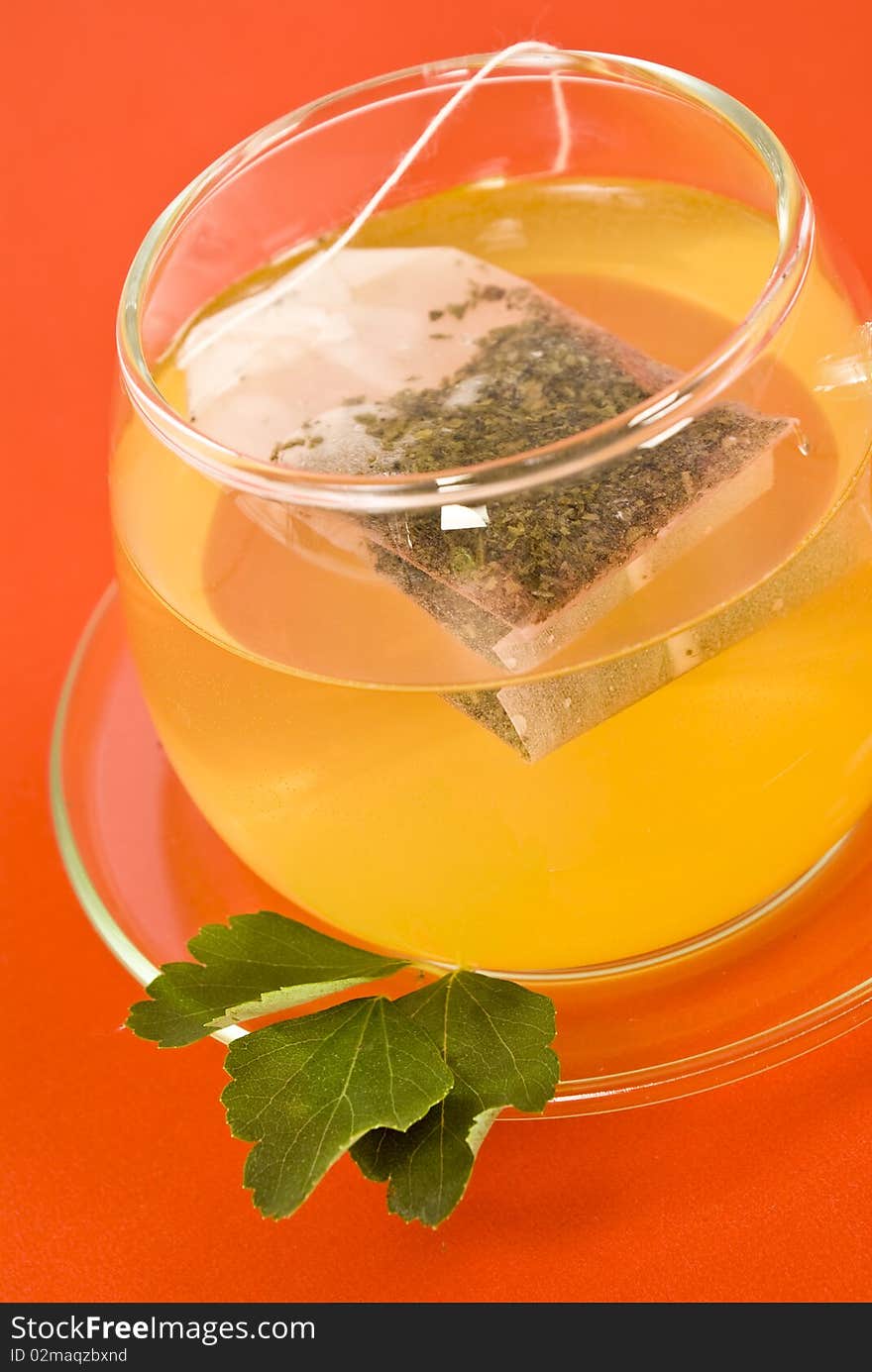 Transparent tea cup on red background