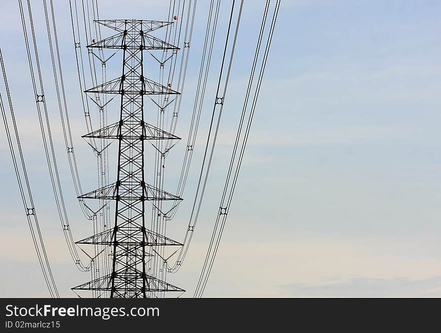 Electric power station in the field in blue cloudy sky