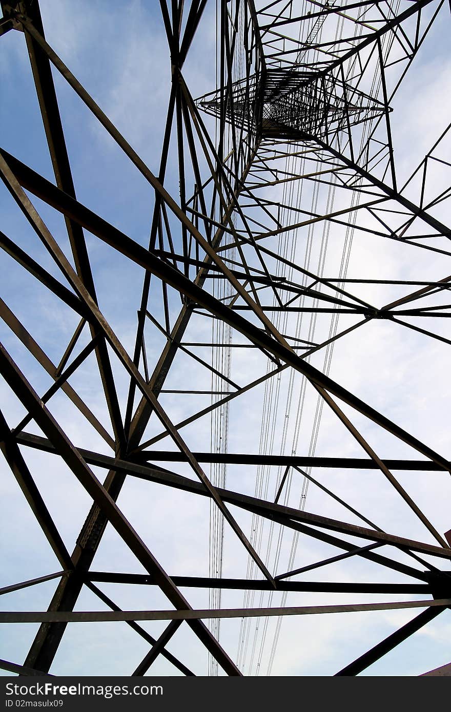 Electric tower against the blue sky and white clouds