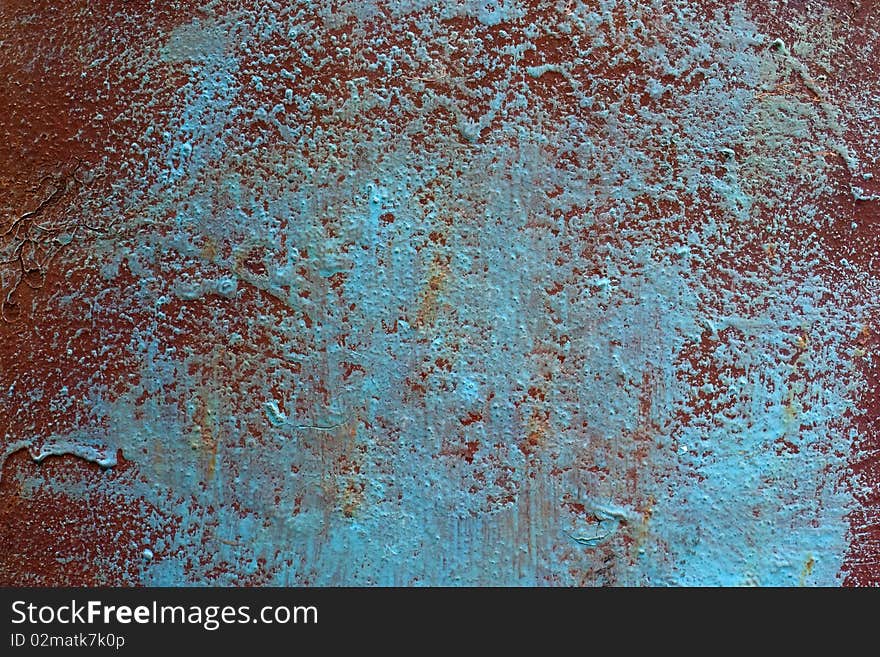 The surface of the painted metal. The lower layer is in warm tones of brown color, the upper layer in the cold tones of blue light