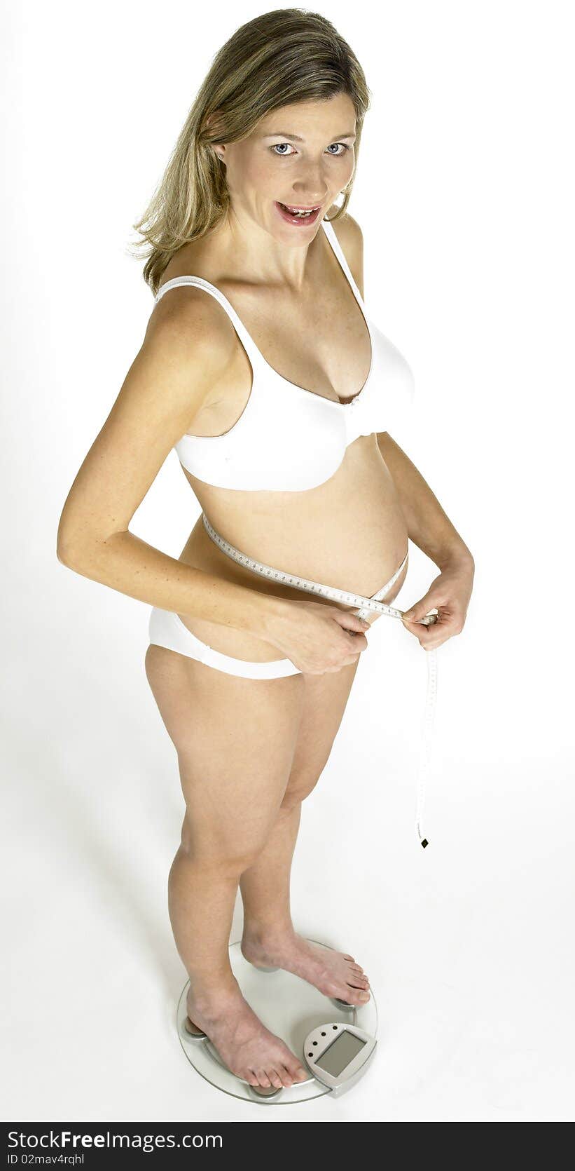 Pregnant woman standing on weight scale