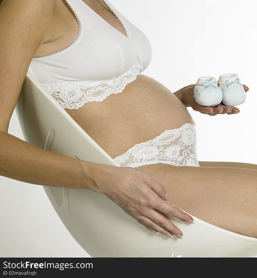 Pregnant woman with shoes for babies