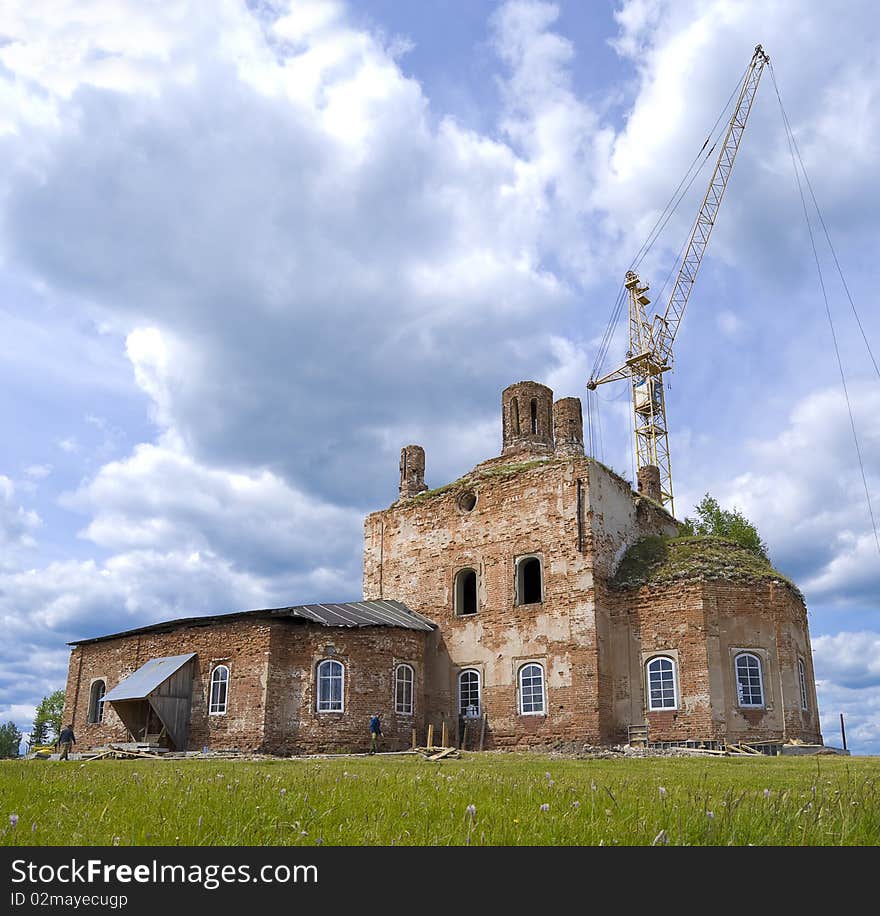 Ortodoxy ancient church is reconstructed. Some workers walking around. At the background there is yellow crane ready to lift up the slab. Ortodoxy ancient church is reconstructed. Some workers walking around. At the background there is yellow crane ready to lift up the slab.