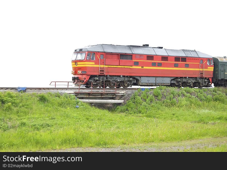 The red locomotive pulls passenger wagons. Isolated on white background. The red locomotive pulls passenger wagons. Isolated on white background