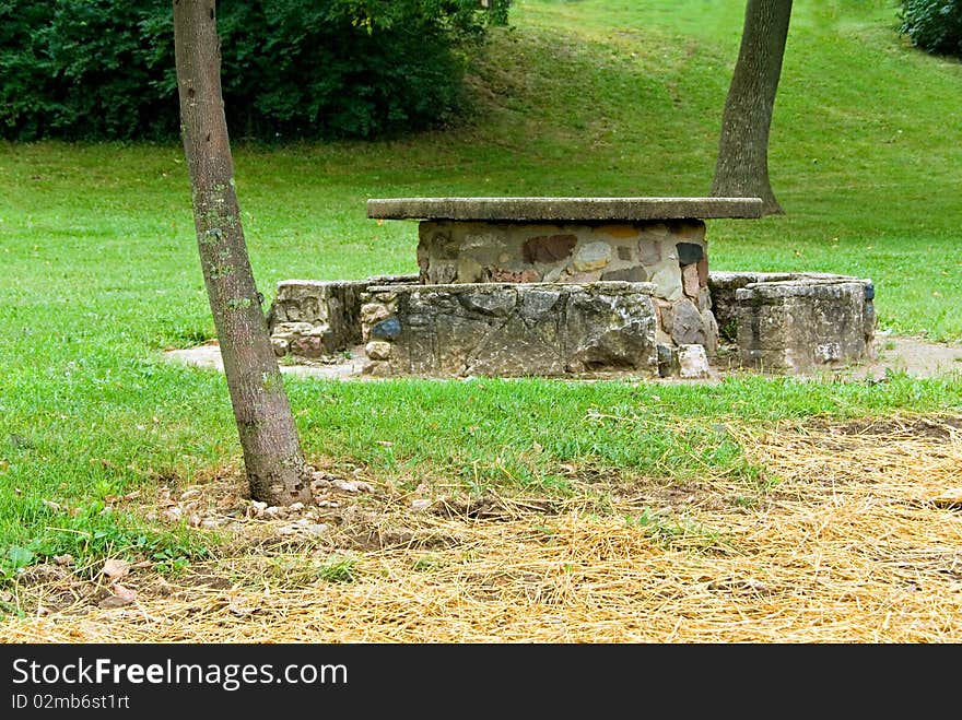 A picnic table on a slopping lawn with straw over newly sown grass. A picnic table on a slopping lawn with straw over newly sown grass.