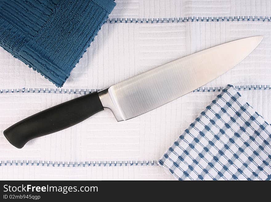 Kitchen professional knife in an environment of napkins from a fabric. Kitchen professional knife in an environment of napkins from a fabric.