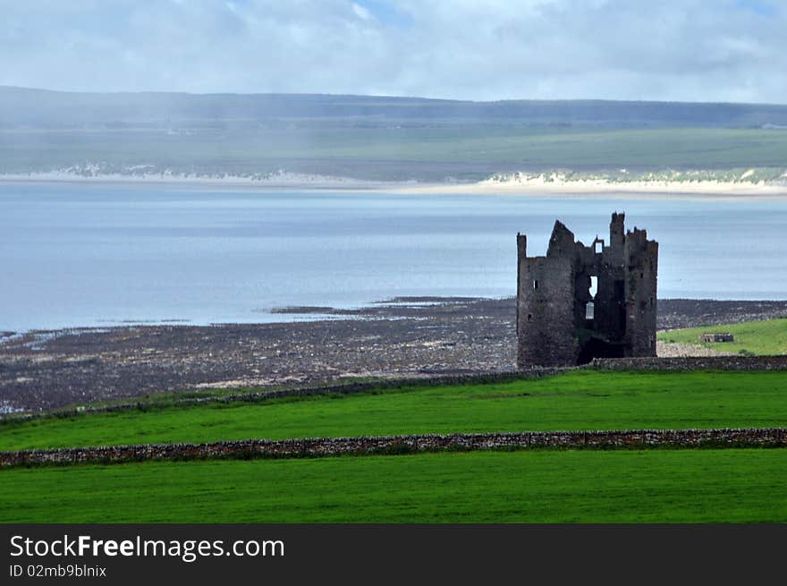 A view Old,Keiss Castle in the mist, Keiss, Caithness, Scotland, UK. Keiss Castle is a partially ruined castle in Scotland, which stands on sheer cliffs overlooking Sinclair&#x27;s Bay less than one mile north of Keiss village centre, Caithness, Highland, Scotland. It is protected as a scheduled monument. The old castle was replaced by Keiss House around 1755. The castle was constructed as a Z-plan tower house with 4 floors plus an attic and a vaulted basement. It had a pair of corner towers at opposite angles of a square central block, the main tower is very narrow for its height with the tall chimney stack. The castle was built possibly on the site of an earlier fort in the late 16th or early 17th century by George Sinclair, 5th Earl of Caithness &#x28;1582-1643&#x29;. It seems the castle was in existence in 1623 when James I commissioned Sir Robert Gordon to enter Caithness with an armed force. The 7th Earl died in the castle in 1698 but it is reported that the castle was ruinous in 1700 and 1726 as being in repair with &#x27;at the side of it a convenient house lately built&#x27;. The estate was purchased by Sir William Sinclair, 2nd Baronet of Dunbeath early in the 18th century and in 1752 Keiss became his family seat. The current house was built about 1755 but had to be sold in 1765 because of financial difficulties to the Sinclairs of nearby Ulbster. This Category B listed baronial mansion was altered to its current form on the instructions of Col. K. Macleay by David