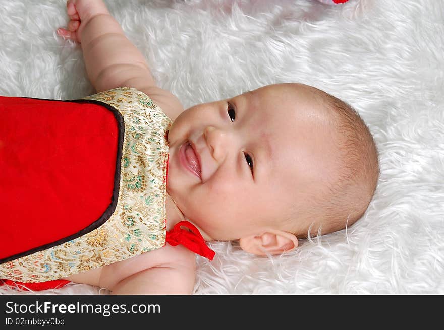 The Chinese infant baby boy lying on white feather. The Chinese infant baby boy lying on white feather