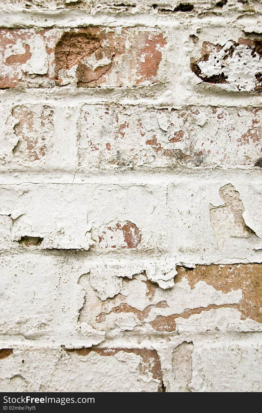 Peeling paint off an old red brick wall. Peeling paint off an old red brick wall