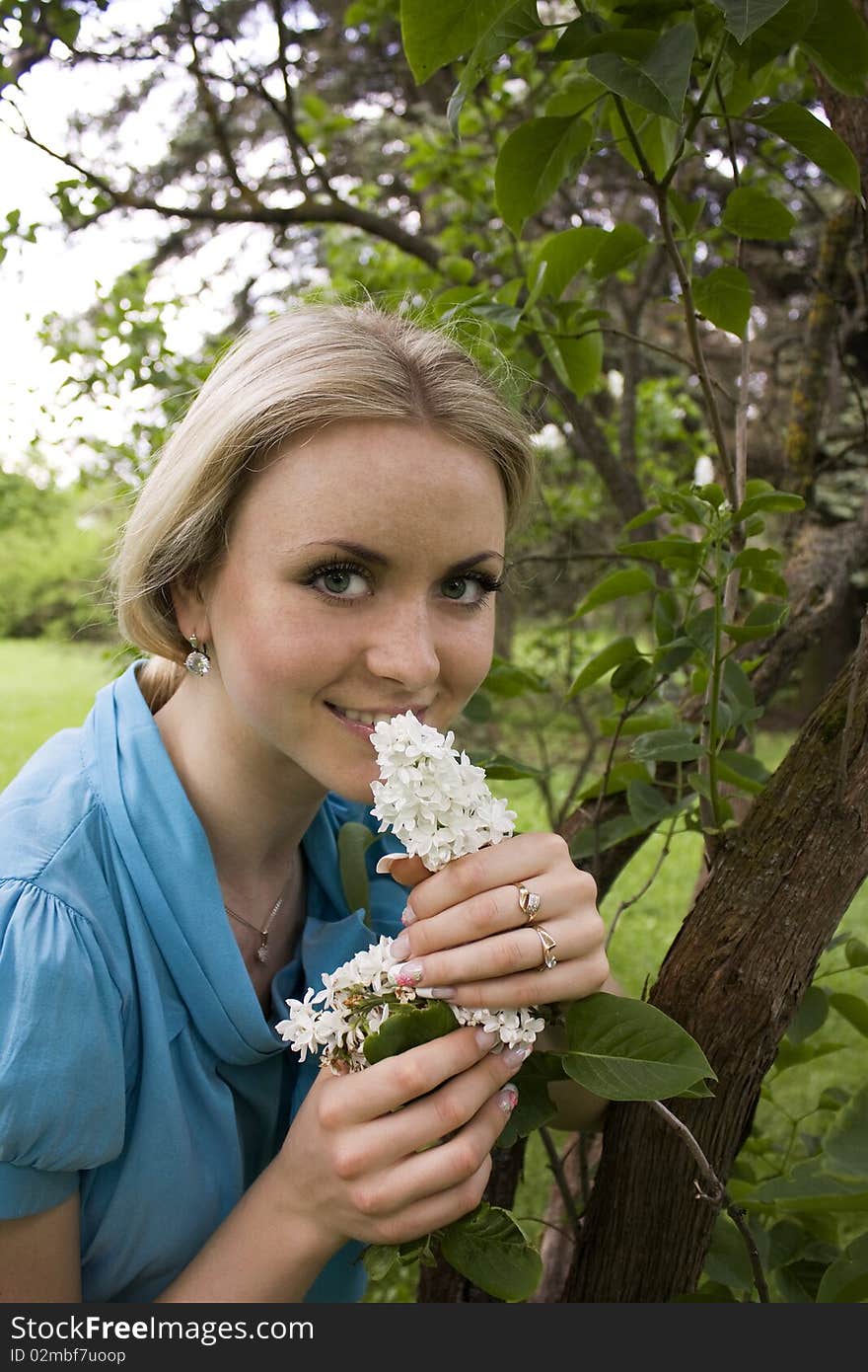 Beautiful Blond Girl Smelling Lilac Blossoms