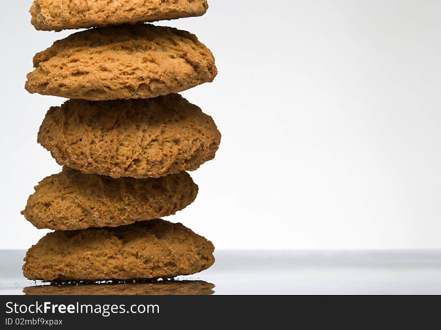 Stack of oaten cookies on reflective surface