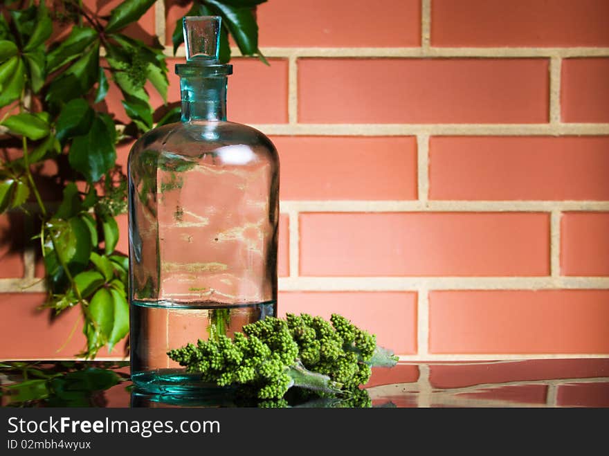 Old bottle with liquid on brick wall background. Old bottle with liquid on brick wall background